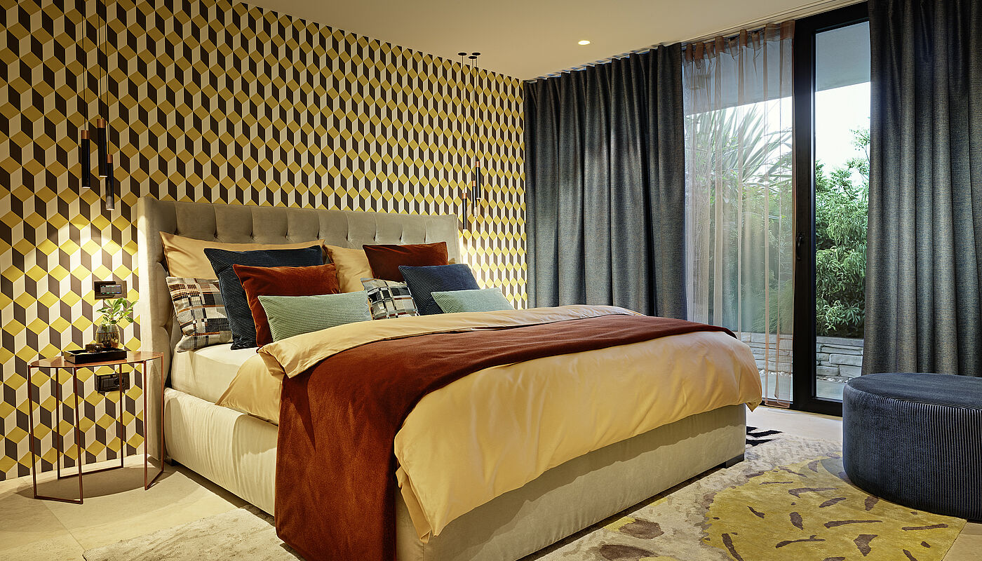 Hohes Bett mit vielen Kissen